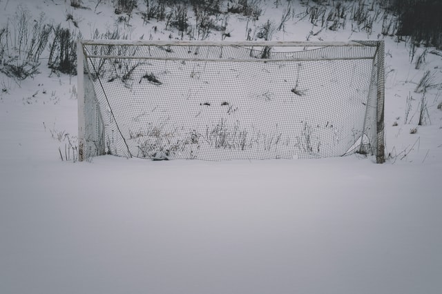Snow covered soccer field and goalposts