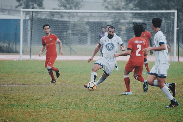 men playing soccer on grass