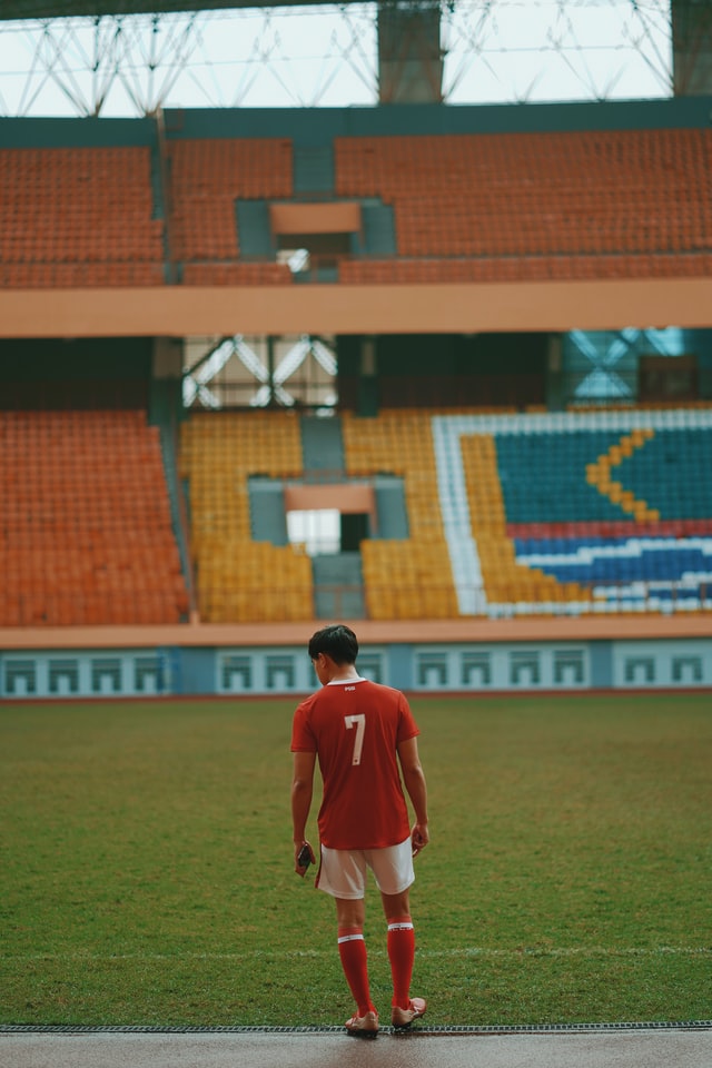 Player returning to soccer field in empty stadium