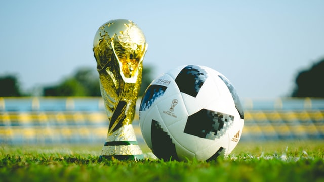 Gold World Cup soccer trophy and black and white ball