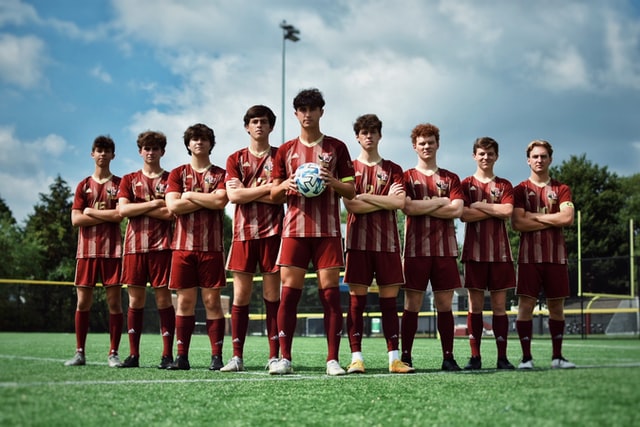 soccer team standing together holding the ball