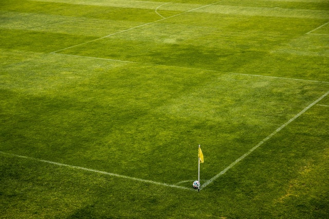 Empty soccer field with corner flag and soccer ball