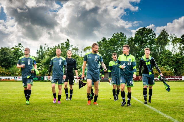 group of men leaving the soccer pitch